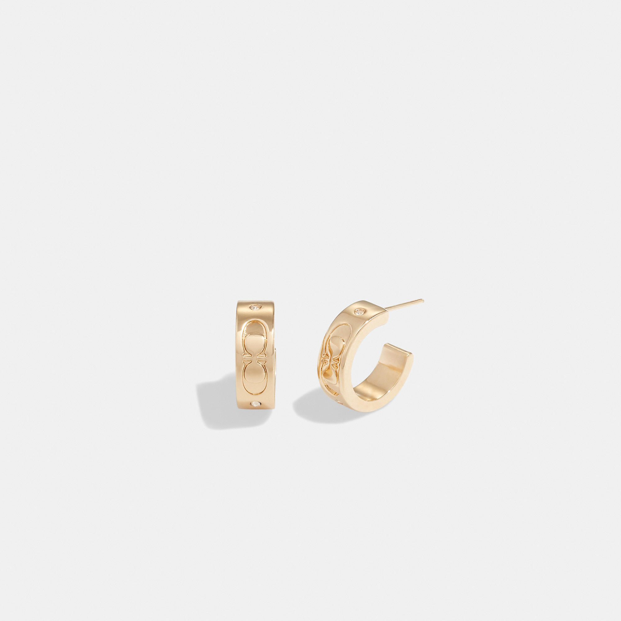 Shop Coach Outlet Signature Huggie Earrings In Yellow