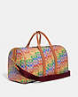 COACH®,GOTHAM DUFFLE IN RAINBOW SIGNATURE CANVAS,Signature Coated Canvas,Large,Burnished Amber Multicolor,Angle View
