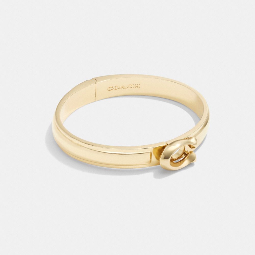 Shop Coach Sculpted Signature Hinged Bangle In Gold